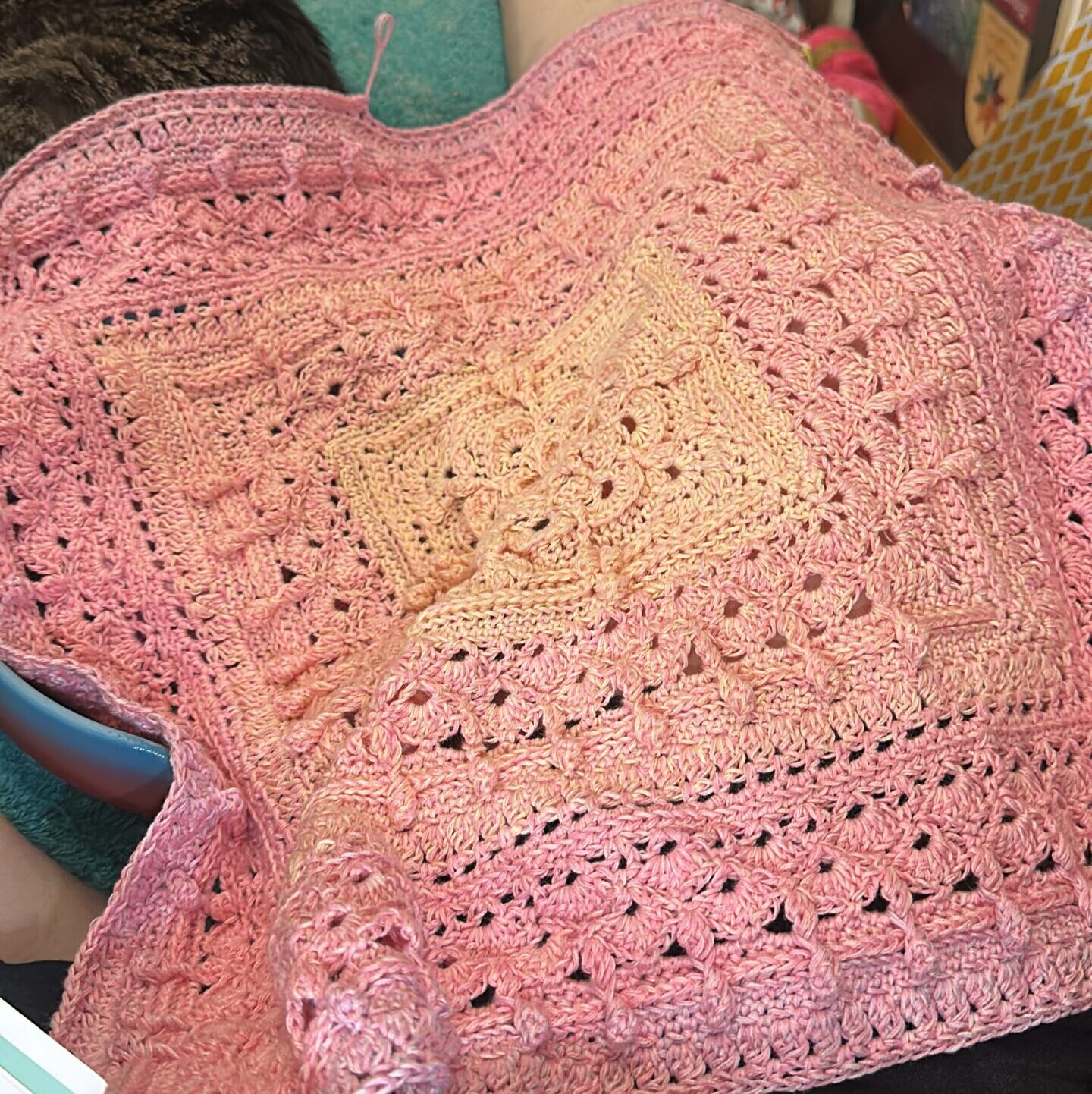 A square of crochet in peach and pink.